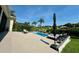 Backyard view featuring a pool, patio with lounge seating, and lush, mature landscaping at 10640 Vista Del Sol Cir, Clermont, FL 34711