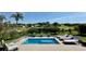 Beautiful view of backyard pool, patio with lounge chairs, and picturesque lush green landscaping at 10640 Vista Del Sol Cir, Clermont, FL 34711