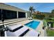 Backyard view of the pool, outdoor seating, and the home's exterior, all surrounded by lush landscaping at 10640 Vista Del Sol Cir, Clermont, FL 34711