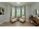Cozy sitting area with chairs, bay window, and a view of the landscaped yard at 10640 Vista Del Sol Cir, Clermont, FL 34711