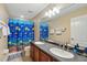 Bright bathroom featuring a double sink vanity, and a fun, colorful fish-themed shower curtain at 1085 Harmony Ln, Clermont, FL 34711