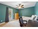 Cozy bedroom with a ceiling fan, neutral carpet, a full-size bed, and a door to the backyard at 1085 Harmony Ln, Clermont, FL 34711
