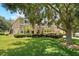 Exterior view of home with mature trees and lush lawn at 1085 Harmony Ln, Clermont, FL 34711