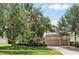 Exterior showcasing a three-car garage, brick driveway, and mature trees enhancing curb appeal at 1085 Harmony Ln, Clermont, FL 34711