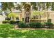 Charming two-story home featuring a manicured lawn, lush landscaping, and an inviting entrance at 1085 Harmony Ln, Clermont, FL 34711