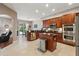 Open kitchen featuring wooden cabinetry, granite counters, stainless appliances, and access to the outdoor space at 1085 Harmony Ln, Clermont, FL 34711
