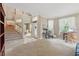Bright and airy living room with high ceilings, large windows, plush carpet, and staircase views at 1085 Harmony Ln, Clermont, FL 34711