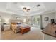 Inviting main bedroom with tray ceilings, ceiling fan, and access to a private balcony at 1085 Harmony Ln, Clermont, FL 34711
