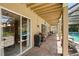 Inviting screened patio with brick flooring, ceiling beams, and views of the pool and backyard at 1085 Harmony Ln, Clermont, FL 34711