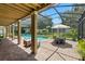 Relaxing screened-in pool area with a brick patio, outdoor dining, and lush landscaping at 1085 Harmony Ln, Clermont, FL 34711