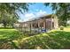 The screened-in pool and lush backyard offers a peaceful retreat with a tranquil water view and an outdoor entertainment area at 1085 Harmony Ln, Clermont, FL 34711