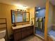 Well-lit bathroom featuring a spacious vanity with granite countertops, a large mirror, and a glass-enclosed shower at 12527 Floridays Resort Dr # 406-E, Orlando, FL 32821