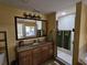 Bright bathroom with a granite-topped vanity, a large mirror, and a clear view of the shower and the bedroom in the mirror at 12527 Floridays Resort Dr # 406-E, Orlando, FL 32821