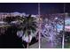 Night view showcasing a community pool, palm trees, and building with illuminated windows reflecting on a pond at 12527 Floridays Resort Dr # 406-E, Orlando, FL 32821
