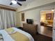 Relaxing main bedroom with a comfortable king bed, dresser, and a glimpse into the cozy living area beyond at 12527 Floridays Resort Dr # 406-E, Orlando, FL 32821