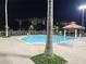 Outdoor pool and lounging area at night with palm trees at 12527 Floridays Resort Dr # 406-E, Orlando, FL 32821