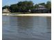 View of a backyard with a tiki hut on the beach and large home with a screened-in back porch at 12765 Se 143Rd Ave, Ocklawaha, FL 32179