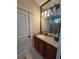 Bathroom with vanity, granite counters, wood cabinets and bronze hardware at 12765 Se 143Rd Ave, Ocklawaha, FL 32179
