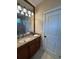 Bathroom with vanity, granite counters, wood cabinets and bronze hardware at 12765 Se 143Rd Ave, Ocklawaha, FL 32179