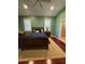 Bedroom with desk, king bed, green walls, and hardwood floors at 12765 Se 143Rd Ave, Ocklawaha, FL 32179