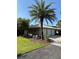 Detached three-car garage with manicured lawn and palm trees at 12765 Se 143Rd Ave, Ocklawaha, FL 32179