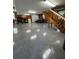 Spacious garage featuring epoxy floors, wood paneled walls, and staircase to the upper level at 12765 Se 143Rd Ave, Ocklawaha, FL 32179