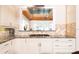 Modern kitchen featuring white cabinets, stone backsplash, stainless hood vent, and gas stovetop at 12765 Se 143Rd Ave, Ocklawaha, FL 32179