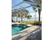 Backyard pool area showcasing the pool, lawn, a lake view, and an American flag at 12765 Se 143Rd Ave, Ocklawaha, FL 32179