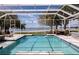 Screened-in pool area with comfortable lounge chairs overlooking the waterfront with ample seating at 12765 Se 143Rd Ave, Ocklawaha, FL 32179