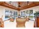 Bright sun room featuring comfortable wicker seating and panoramic views of the pool and waterfront at 12765 Se 143Rd Ave, Ocklawaha, FL 32179