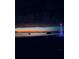 Scenic waterfront view at dusk featuring a boat, tiki hut, and a Christmas tree illuminated with blue lights at 12765 Se 143Rd Ave, Ocklawaha, FL 32179