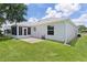 View of the backyard with a screened in lanai, small patio area, and view of the home's siding at 1305 Guerra Ave, The Villages, FL 32159