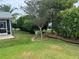 Lush backyard with well-maintained lawn, landscaping, and screened-in porch at 1305 Guerra Ave, The Villages, FL 32159