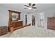 Spacious bedroom featuring wood dresser, mirror and ensuite bathroom and walk-in closet access at 1305 Guerra Ave, The Villages, FL 32159