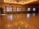 Large event space with hardwood floors, chandeliers, and many windows at 1305 Guerra Ave, The Villages, FL 32159