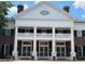 Front view of a brick building featuring symmetrical architectural design with white columns and a well-maintained exterior at 1305 Guerra Ave, The Villages, FL 32159