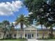 Exterior of El Santiago Recreation Center with tropical landscaping and blue skies at 1305 Guerra Ave, The Villages, FL 32159