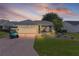 Exterior of a well-maintained home with a paver driveway and a blue golf cart at sunset at 1305 Guerra Ave, The Villages, FL 32159