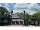 A charming, two-story brick building with a white-columned portico, complete with planters and a well-manicured landscape at 1305 Guerra Ave, The Villages, FL 32159