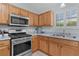 Kitchen showcases stainless steel appliances, including a Maytag microwave and gas range, and light blue countertops at 1305 Guerra Ave, The Villages, FL 32159