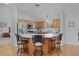 Open-concept kitchen features stainless steel appliances, wood cabinets, and an island with barstool seating at 1305 Guerra Ave, The Villages, FL 32159