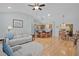 Open-concept living space with a ceiling fan, hardwood floors, and a view into the kitchen and dining area at 1305 Guerra Ave, The Villages, FL 32159