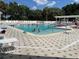 Community pool with sunbathers and swimmers on a sunny day at 1305 Guerra Ave, The Villages, FL 32159