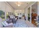 Comfortable sunroom with sliding glass doors, ceiling fan, tile flooring, and view to the interior home office at 1305 Guerra Ave, The Villages, FL 32159