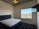 Bedroom with a large window offering a scenic city view, concrete ceiling, and modern ceiling fan at 155 S Court Ave # 1801, Orlando, FL 32801