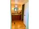 Bathroom features wood cabinets, a sink, a mirror and a window for natural light at 201 Jacaranda Dr, Leesburg, FL 34748