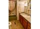 Bathroom features an olive green tub, tile flooring, and wood cabinets with a sink at 201 Jacaranda Dr, Leesburg, FL 34748