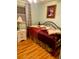 Cozy bedroom featuring a decorative bed frame, laminate wood flooring, and soft, natural light from the window at 201 Jacaranda Dr, Leesburg, FL 34748