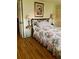 Single bedroom with floral bedding, wrought iron bed frame, side table and bedside lamp at 201 Jacaranda Dr, Leesburg, FL 34748