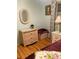 Bedroom showcasing a wicker dresser, wicker end table, light from a window and wood laminate flooring at 201 Jacaranda Dr, Leesburg, FL 34748